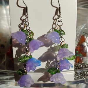 Anna luonnon kauneuden kukkia korvillasi. Nämä satumaiset Kellokukka-korvakorut tuovat mieleen kesäisen niityn ja keijukaisten leikit. Korvakoruissa on herkkää kerroksellisuutta: pastellinsävyiset, läpikuultavat kukkaset ja pienet vihreät lehdet laskeutuvat sirosti teräsketjussa, luoden eläväisen ja kevyen liikkeen